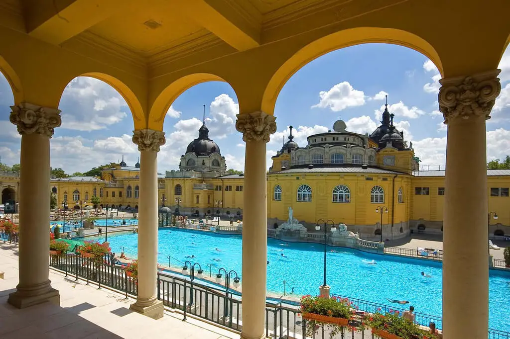 Baños termales Széchenyi en Budapest con piscinas al aire libre y arquitectura histórica amarilla en verano