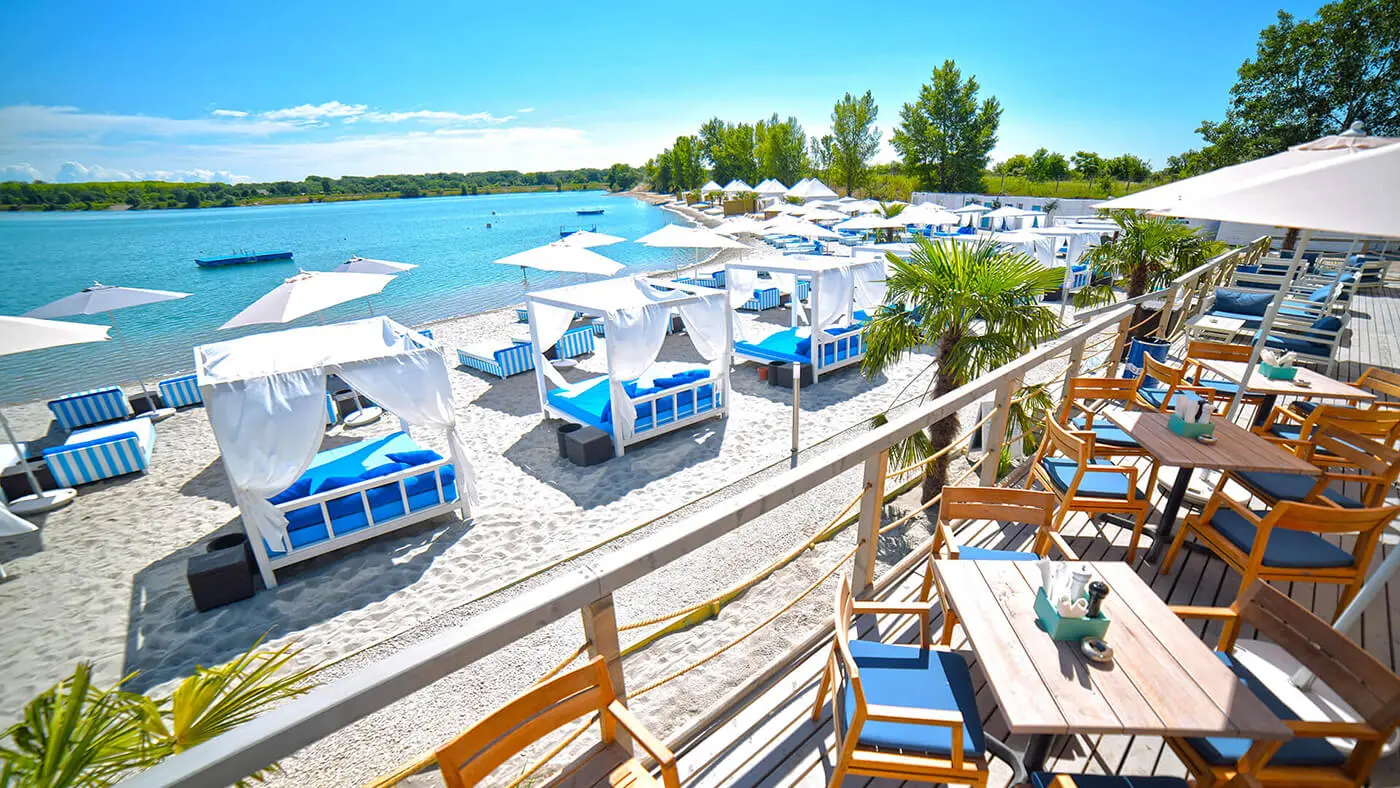 Lupa Beach near Budapest with white sand, loungers, and umbrellas on a sunny summer day