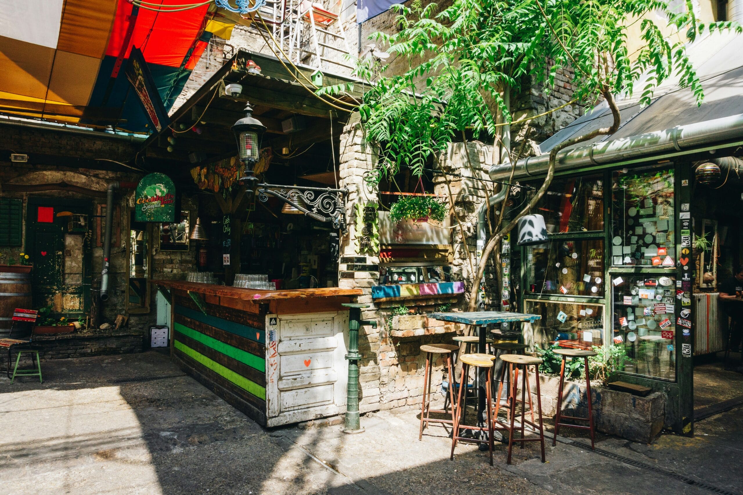 Courtyard of Szimpla Kert ruin bar in Budapest with outdoor bar and colorful atmosphere
