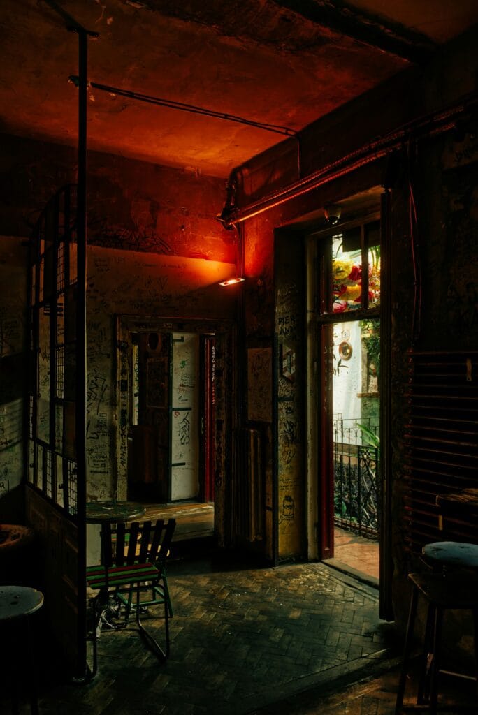 Interior of Szimpla Kert ruin bar in Budapest with red light and eclectic decor