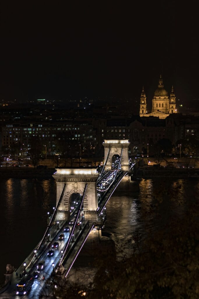St. Stephen’s Basilica illuminated at night behind the Chain Bridge over the Danube in Budapest