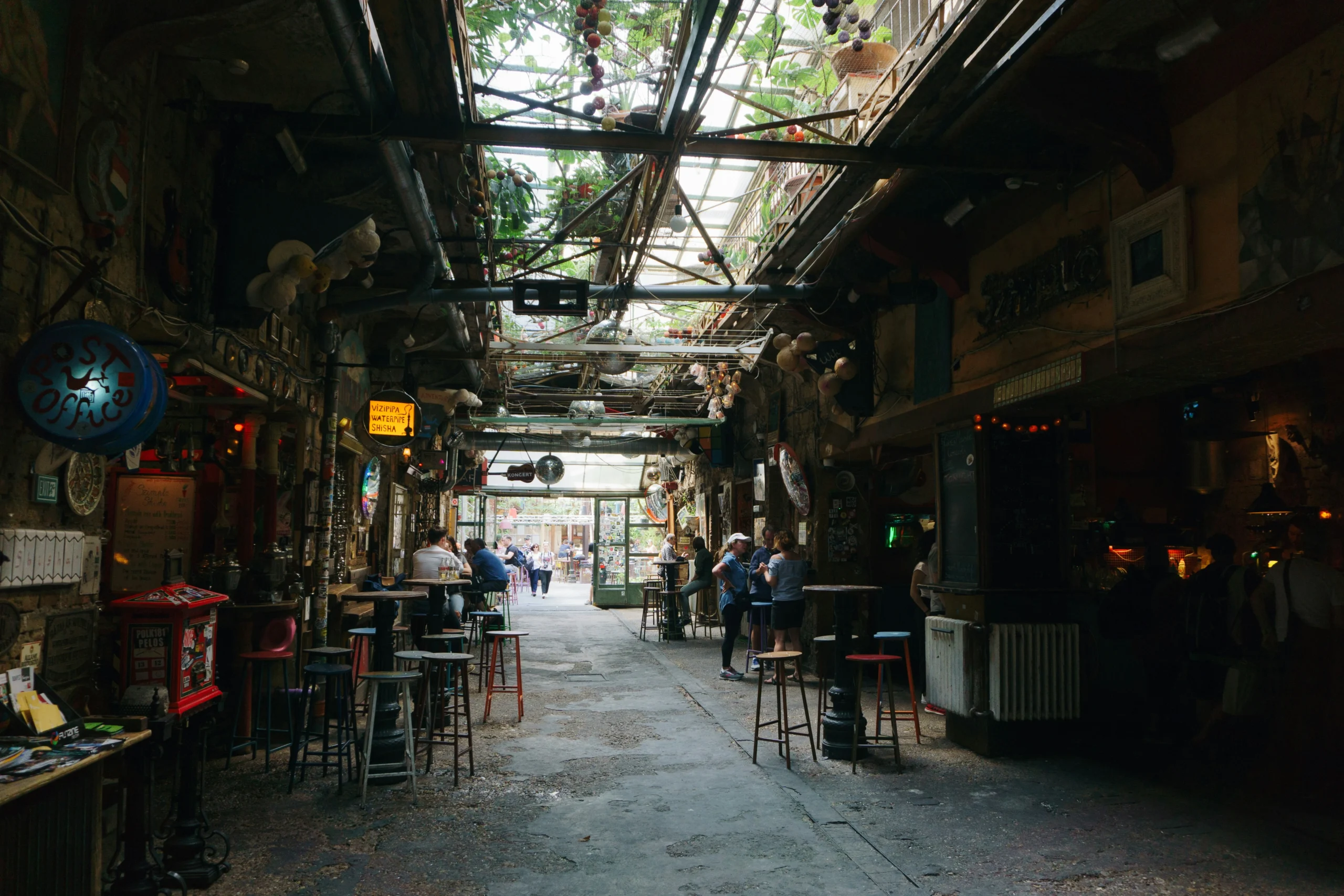 Interior view of Szimpla Kert, Budapest’s most famous ruin bar, with eclectic decor and open ceiling.