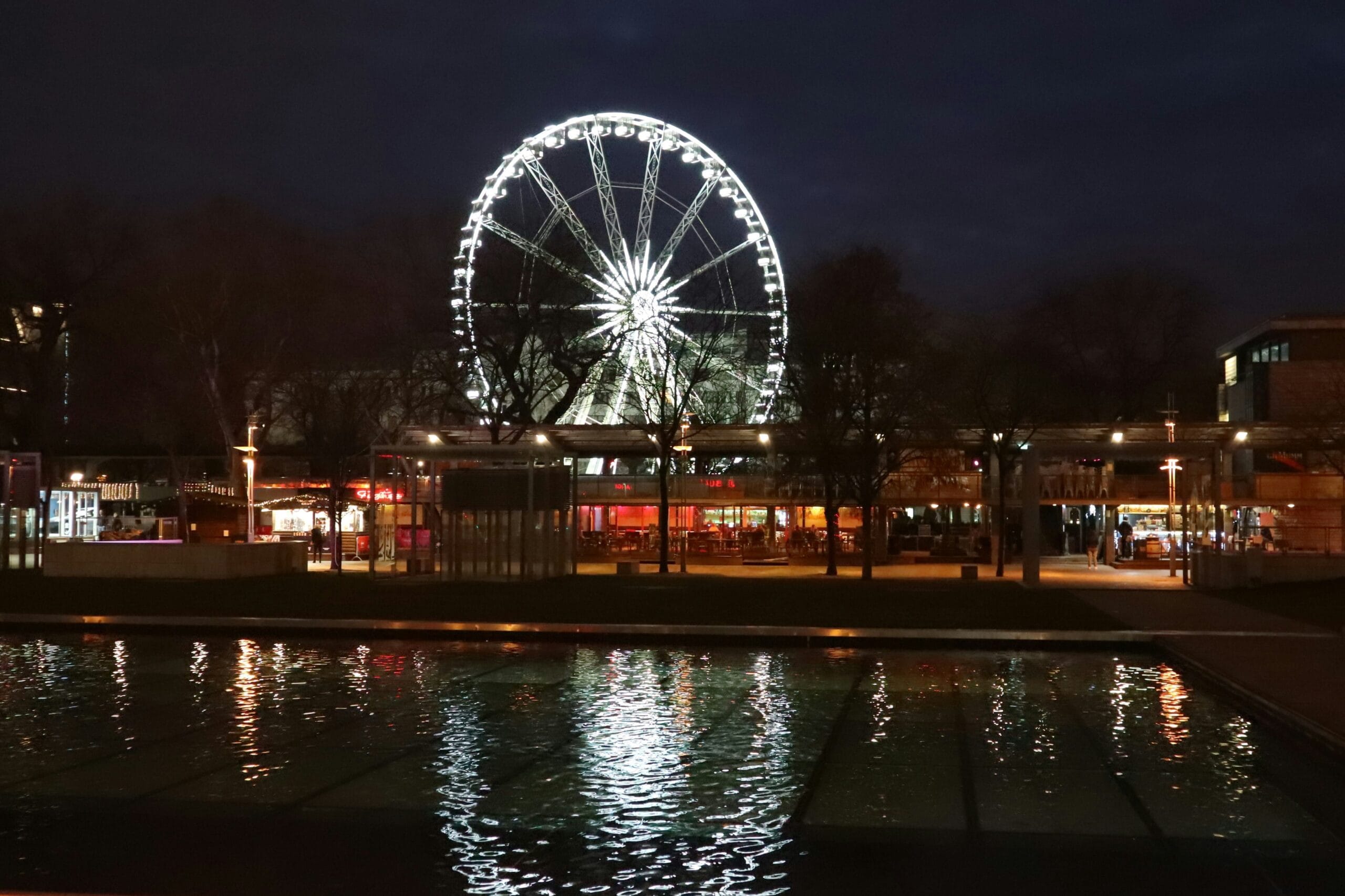 Budapest Eye de noche en la Plaza Erzsébet con luces reflejadas en el agua